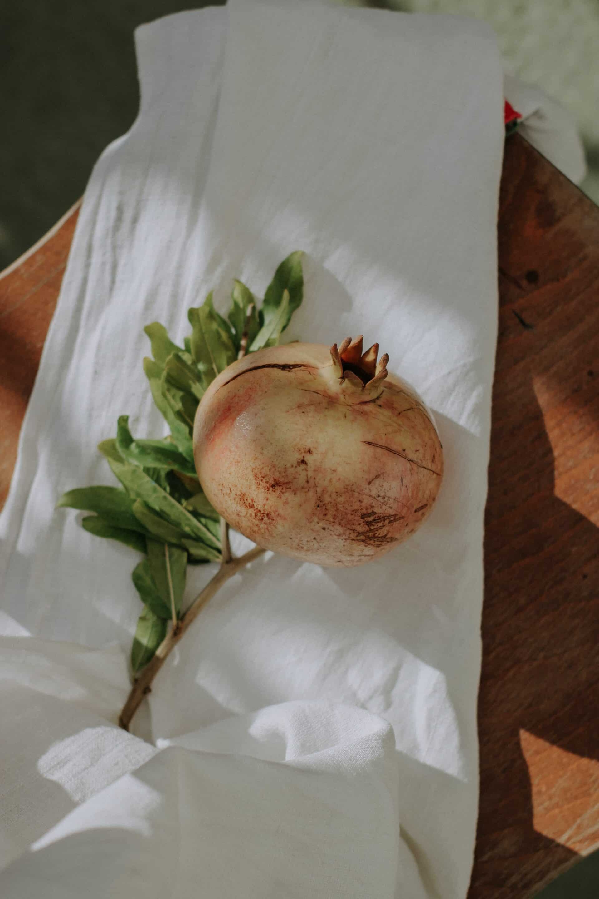 Un fruit de grenade posé sur un linge en coton